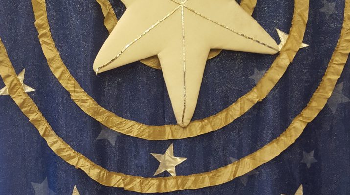 a fabric banner, showing a star over a manger